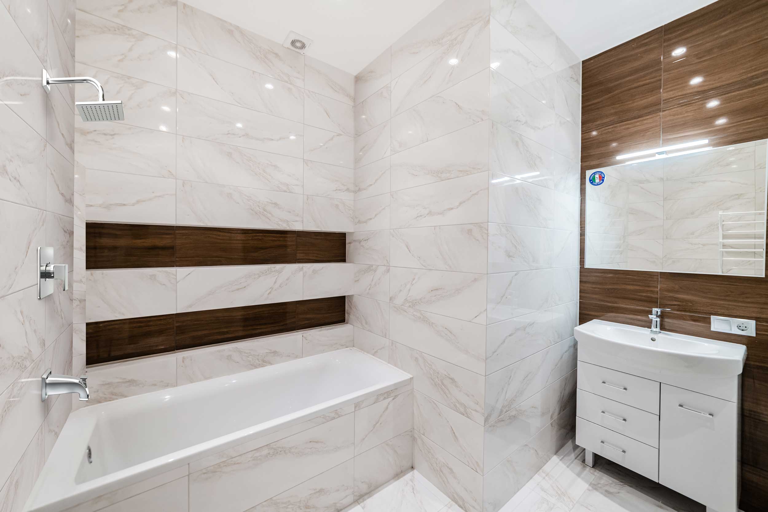 Copy-of-001OM4-T_Lifestyle- A modern bathroom featuring a stylish combination of white and brown tiles on the walls and floor.
